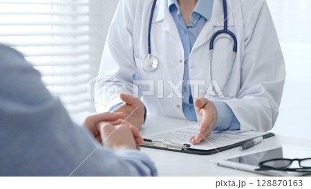 Female doctor explaining diagnosis to her patient during medical consultation in medical office, healthcare and medical concept. Medicine and healthcare concept Female doctor explaining diagnosis to her patient during medical consultation in medical office, healthcare and medical concept. Medicine and healthcare concept 128870163
