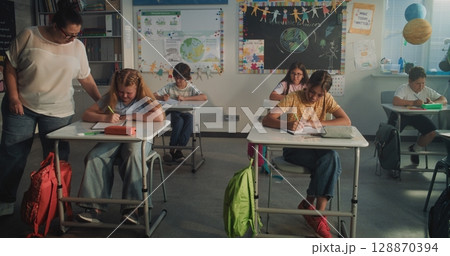 Concentrated Primary School Children Writing School Test in Modern Classroom Concentrated Primary School Children Writing School Test in Modern Classroom 128870394