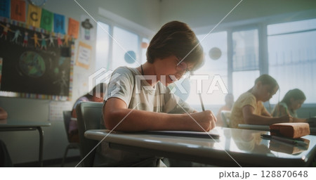 Concentrated Primary School Children Writing School Test on Geography in Modern Classroom Concentrated Primary School Children Writing School Test on Geography in Modern Classroom 128870648