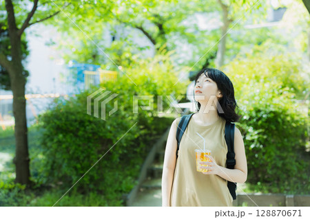 緑の中を歩く女性 128870671