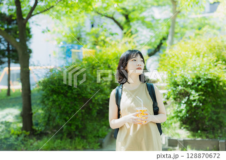 緑の中を歩く女性 128870672