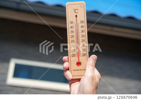 猛暑日 家の近くで外気温39℃の温度計を持つ女性の手 猛暑日 家の近くで外気温39℃の温度計を持つ女性の手 128870696