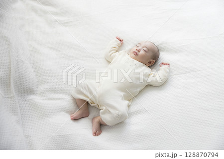 ベッドに寝転ぶ赤ちゃん　  128870794