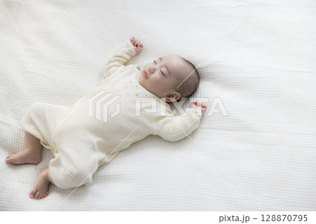 ベッドに寝転ぶ赤ちゃん　  128870795