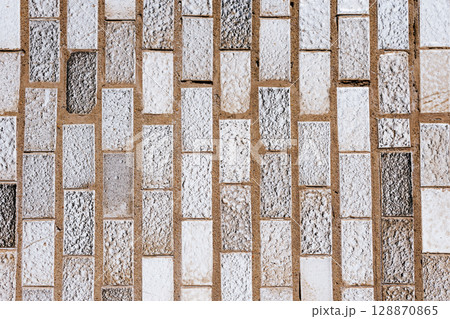 stone mosaic texture. small stone parallelepipeds.old building facade 128870865