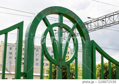 There is a green fence that has the letter v prominently displayed on it There is a green fence that has the letter v prominently displayed on it 128871538