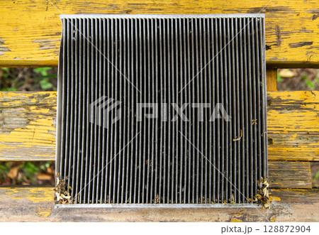Replacing an old dirty cabin filter with a new one. Car maintenance, close-up 128872904