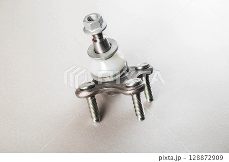 Automotive spare part ball joint on gray background, isolate. Car suspension part, close-up Automotive spare part ball joint on gray background, isolate. Car suspension part, close-up 128872909