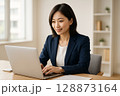 笑顔でパソコン作業をする若い女性 128873164