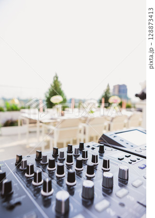 Outdoor DJ setup at dusk, bathed in dynamic lights Outdoor DJ setup at dusk, bathed in dynamic lights 128873413
