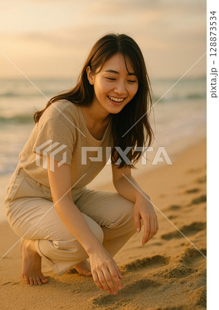 夕暮れの海辺で微笑む若い女性・穏やかなひととき 128873534