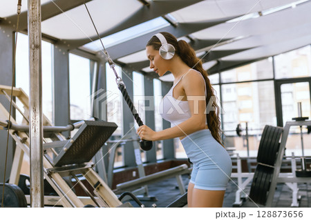Sexy fitness woman doing exercises. Healthy lifestyle concept. Cross-fit bodybuilder in gym. 128873656