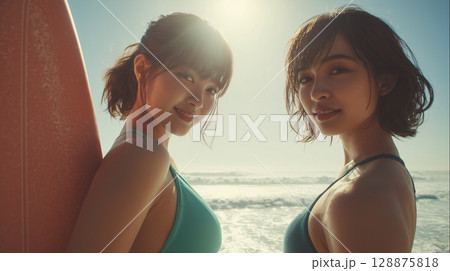 海辺の砂浜でサーフボードを抱えながら歩く日本人女性 128875818