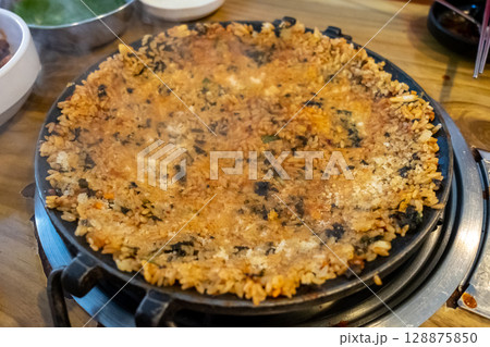 Crispy fried rice on pan, made by mixing rice, seaweed and sauce. Korean food 128875850