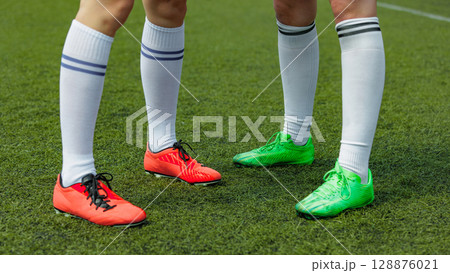 Women soccer athletes donned vibrant cleats on lush green field Women soccer athletes donned vibrant cleats on lush green field 128876021
