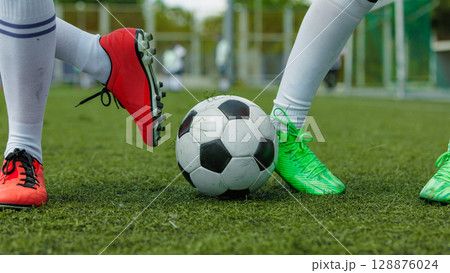 Female soccer athletes vying for ball on lush field during thrilling game Female soccer athletes vying for ball on lush field during thrilling game 128876024