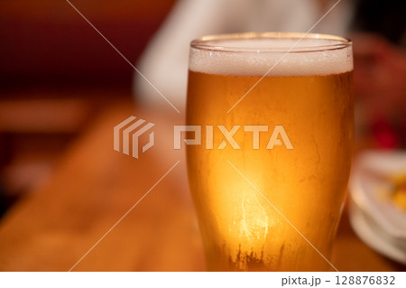 Close up of beer in a glass with blur background Close up of beer in a glass with blur background 128876832