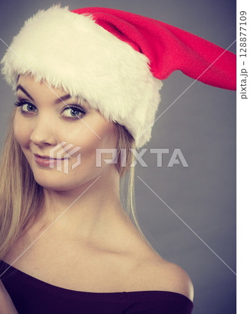 Happy woman wearing Santa Claus helper hat Happy woman wearing Santa Claus helper hat 128877109