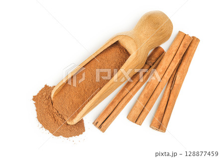 Cinnamon sticks with powder in wooden scoop isolated on white background. Top view. Flat lay. Cinnamon sticks with powder in wooden scoop isolated on white background. Top view. Flat lay. 128877459