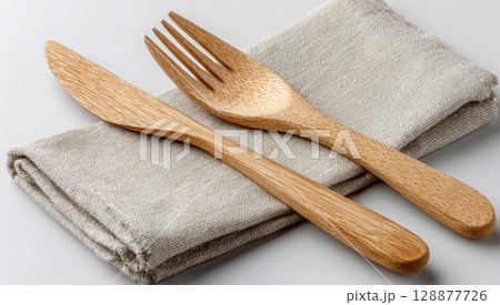 Wooden bamboo fork and knife on canvas cloth napkin on white background, eco friendly life Wooden bamboo fork and knife on canvas cloth napkin on white background, eco friendly life 128877726