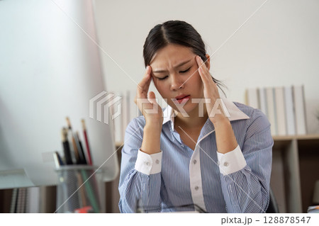 Office Syndrome: Young woman experiencing stress and discomfort at her desk 128878547