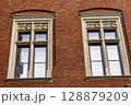 Ornate Stone Framed Windows on a Red Brick Building 128879209
