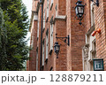 Historic Brick Building Facade with Ornate Lamps and Number 13 128879211