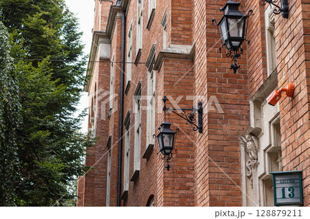 Historic Brick Building Facade with Ornate Lamps and Number 13 128879211