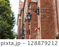 Ornate Street Lamps and Red Brick Wall on a Historic Building 128879212