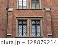 Historic Brick Building Facade with Ornate Windows and Stone Details 128879214