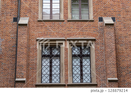 Historic Brick Building Facade with Ornate Windows and Stone Details Historic Brick Building Facade with Ornate Windows and Stone Details 128879214