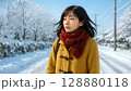 雪の降った道を歩く女性 128880118