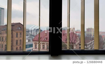 A stunning cityscape view observable through the intricate bars of a window frame 128880448