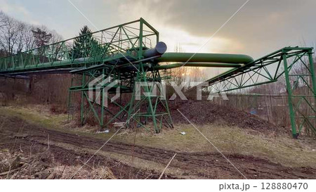 The Industrial Infrastructure Featuring a Green Pipeline Stands Out Against a Dramatic Sky The Industrial Infrastructure Featuring a Green Pipeline Stands Out Against a Dramatic Sky 128880470