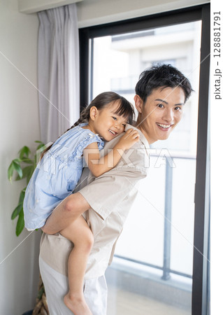笑顔で遊ぶ父娘のふれあいシーン 128881791