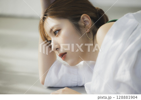 床に寝転ぶ女性 128881904
