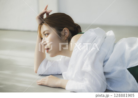 床に寝転ぶ女性 128881905