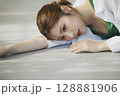 床に寝転ぶ女性 128881906