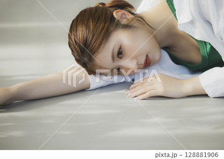 床に寝転ぶ女性 128881906