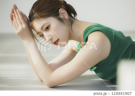 床に寝転ぶ女性 128881907