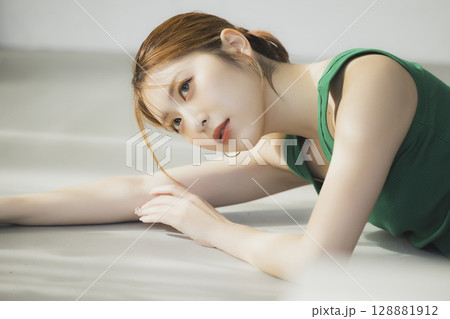 床に寝転ぶ女性 128881912