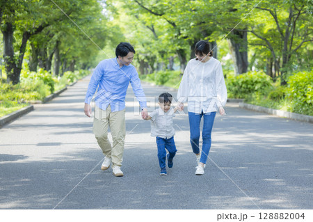 新緑の公園を歩く家族  128882004