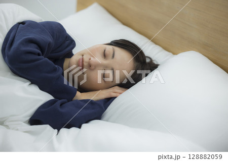 ベッドで寝る女性 128882059