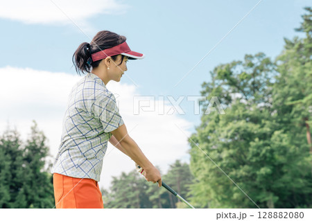 ゴルフ場でゴルフをするゴルファーの女性(ティーショット・ゴルフコンペ) 128882080