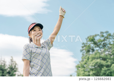 ゴルフ場でゴルフをするゴルフウェアを着たゴルファーの女性 128882081