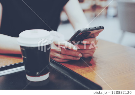 カフェでスマホを見ている女性の手元 カフェでスマホを見ている女性の手元 128882120