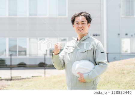 作業着姿のヘルメットを持つ作業員のアジア人男性 作業着姿のヘルメットを持つ作業員のアジア人男性 128883440