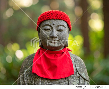 優しい微笑み：赤いよだれかけをつけたお地蔵様 128885097