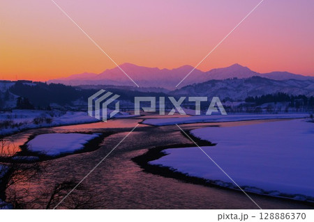 朝焼けの越後三山・信濃川朝焼けの夜明け雪景色 128886370