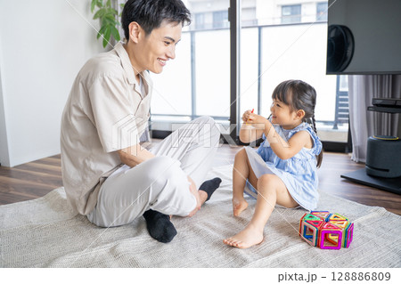 おもちゃで遊ぶパパと娘の笑顔あふれる時間 128886809